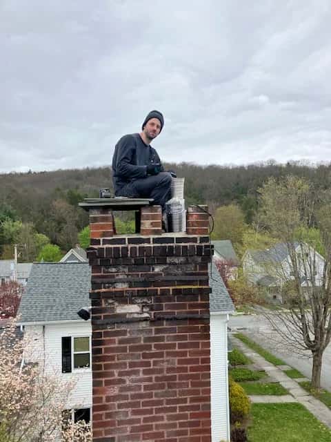 Sam Zuchowski working on a brick chimney with a stainless steel liner.